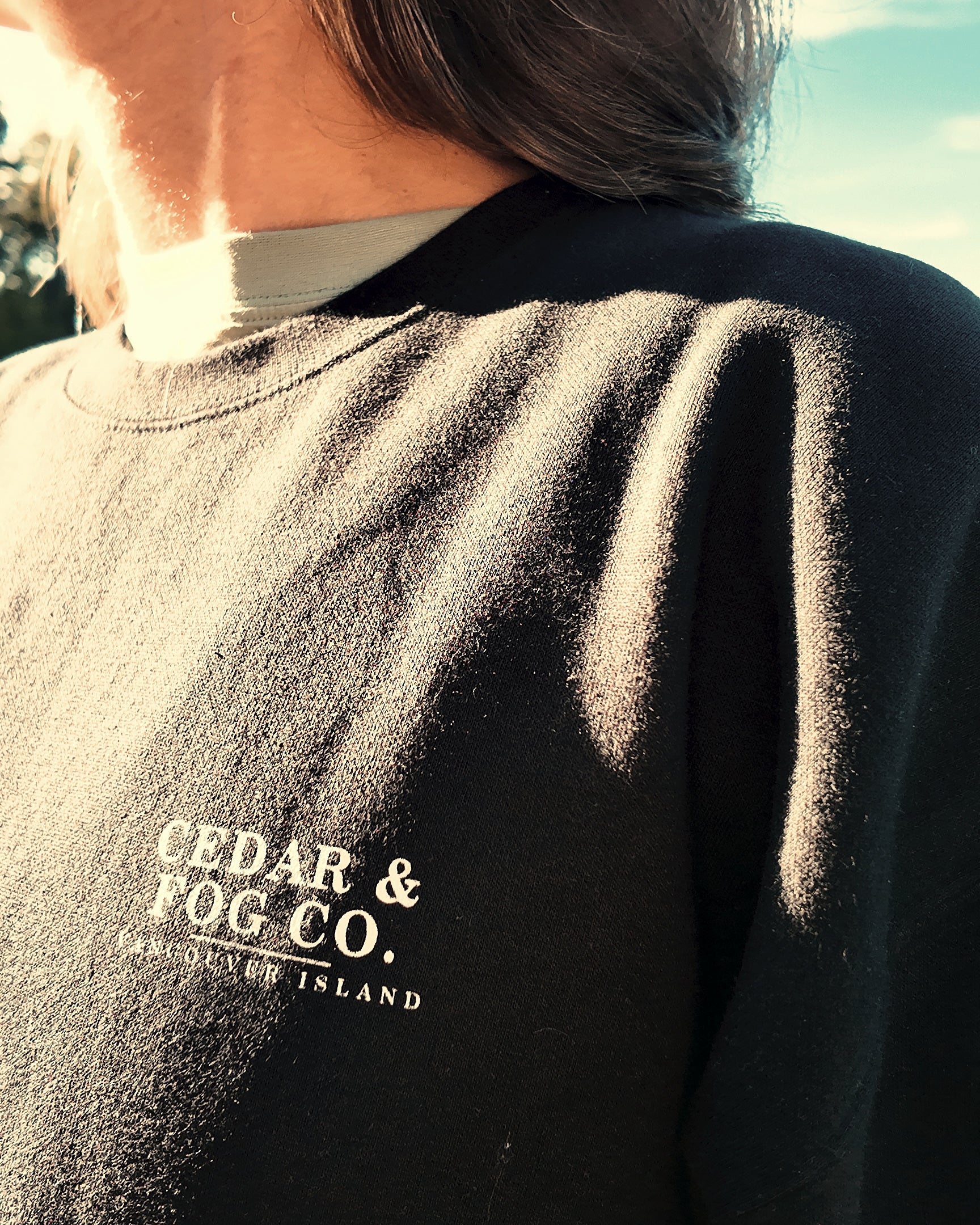 The Nightfall Crew in black showing the Cedar & Fog Co. Vancouver Island chest print, worn outdoors