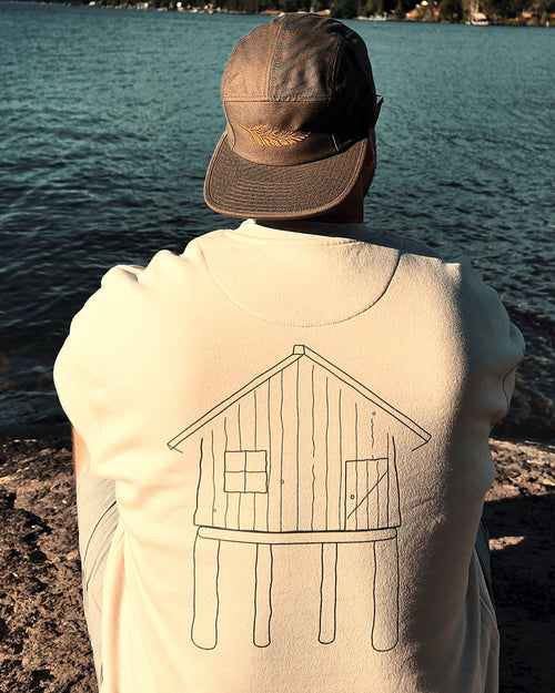 The Cabin Crew in bone by the lake, hand-drawn cabin printed across the back