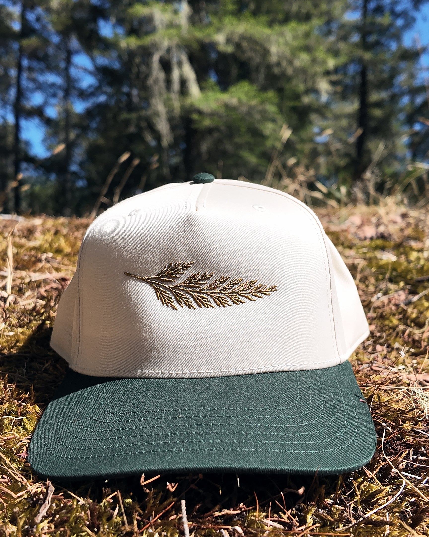 The Ranger Cap in dark green and natural with the embroidered cedar bough